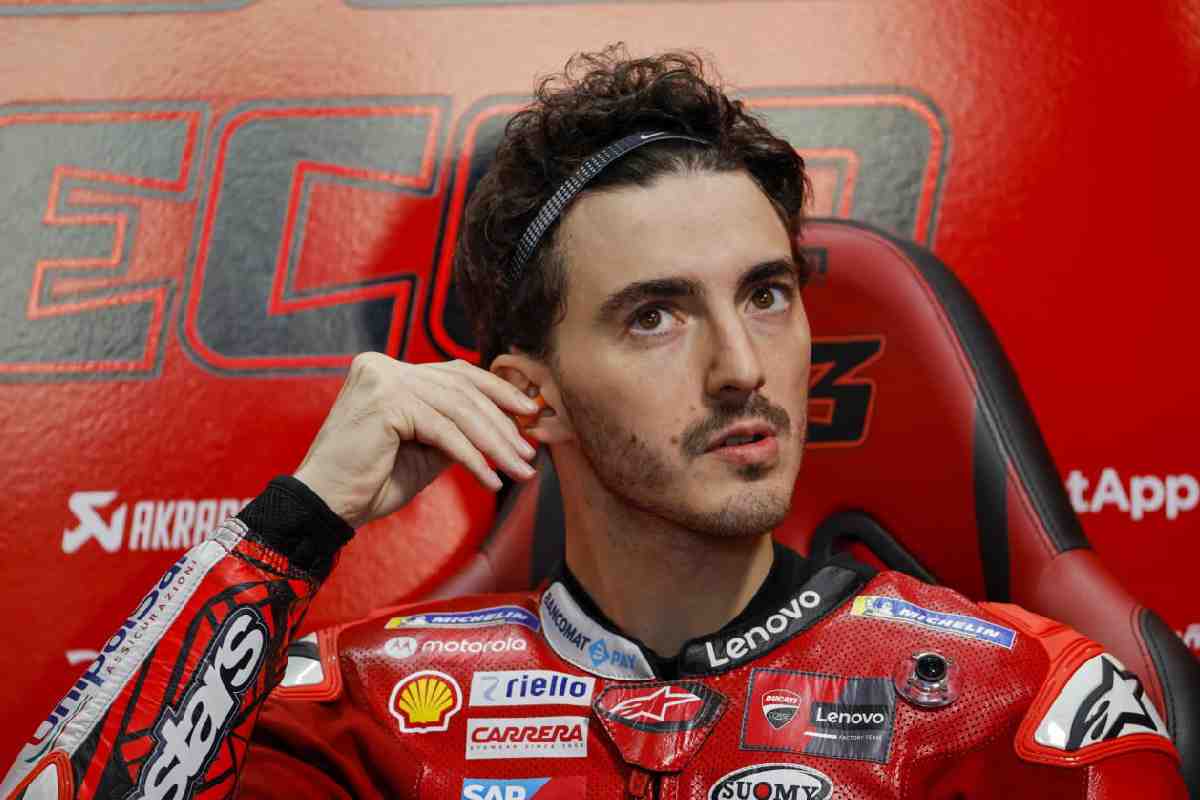 Pilota Bagnaia vestito di rosso su sfondo rosso