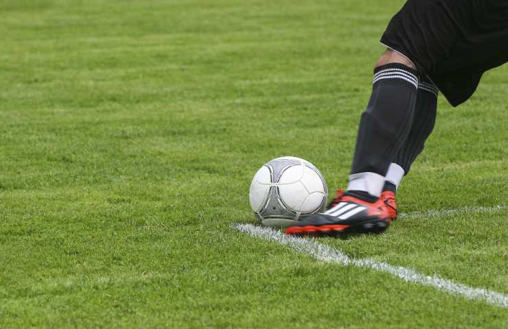 immagine del piede di un giocatore iche da un calcio al pallone